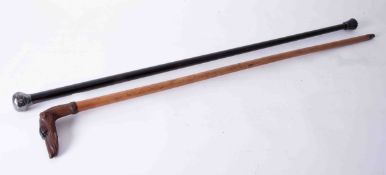 A silver mounted and ebonised walking cane together with a wood walking cane the handle carved in