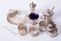 Five assorted silver napkin rings, a silver and scallop shell butter dish and a three piece silver