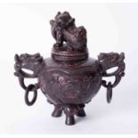 An oriental carved sensor in a red hardstone? with cover, height 21cm.