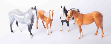 Four Beswick horses including two Palomino's, 'Pinto Pony' and a Roan Hunter, height 20cm.