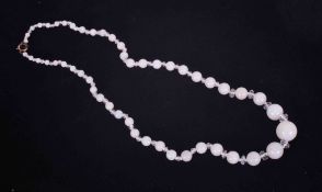 A graduated string of white opal beads interspaced with faceted glass beads, the largest opal bead