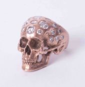 A 9ct rose gold? (not tested) skull design ring set with approx. 2.85 carats of round brilliant