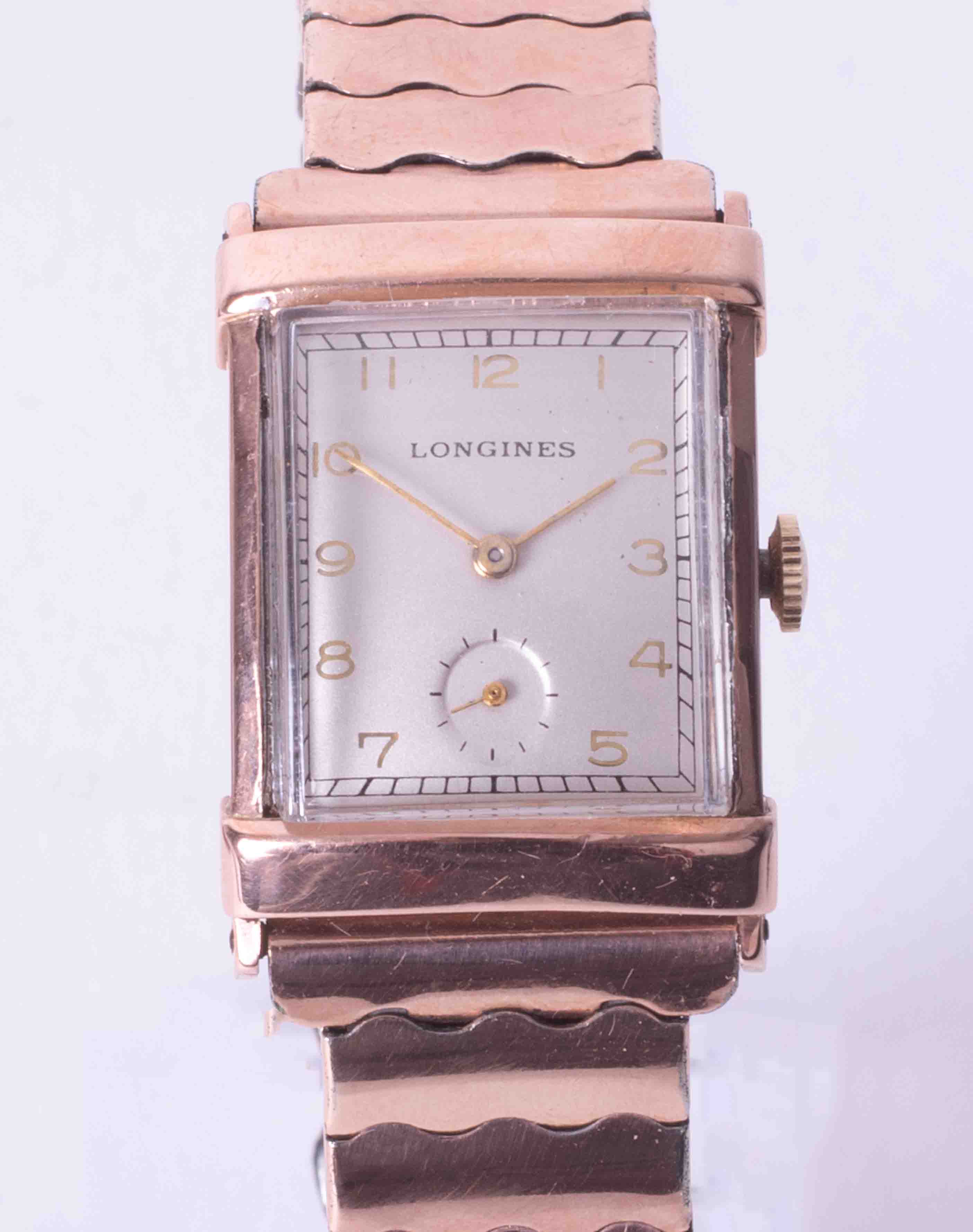 Longines, a gents mid size rectangular cased rose colour (gold filed) wristwatch, integral expanding