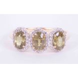 A 9ct yellow gold three stone ring set 1.85 carats of oval demantoid garnet surrounded by 0.30