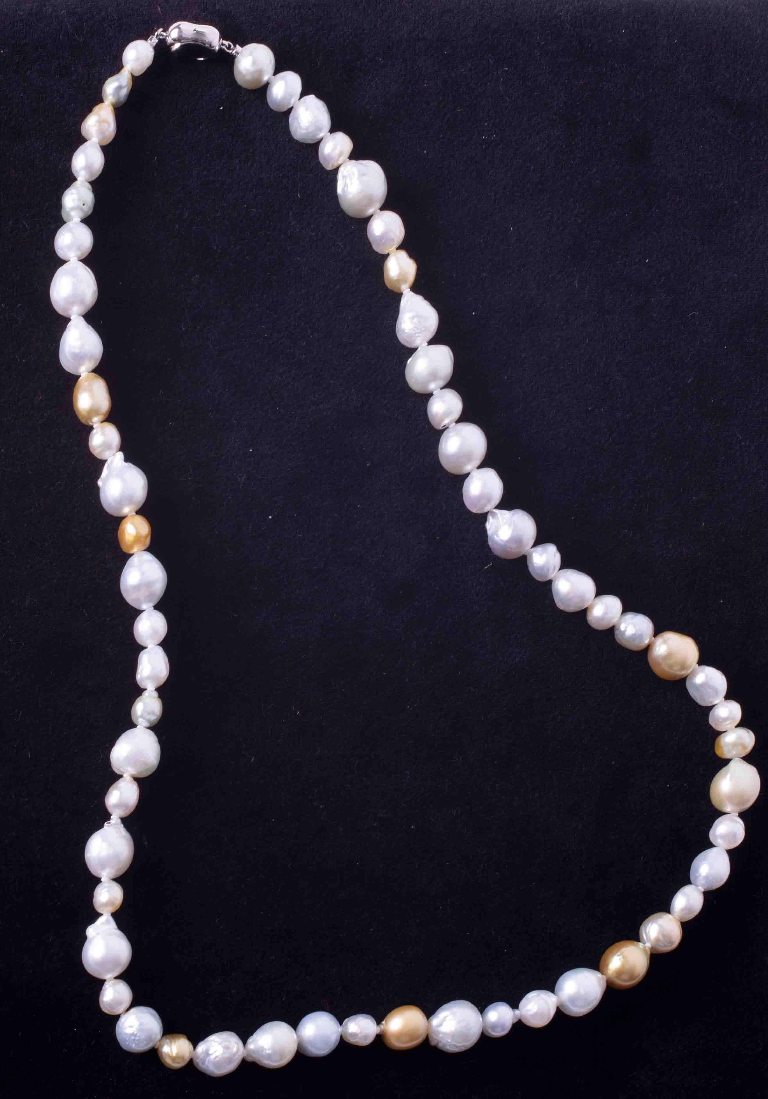 A 28" strand of champagne & white baroque south sea pearls ranging from 14mm down to 8mm strung to a