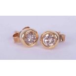 A pair of 18ct yellow gold rub over studs set a total weight of 0.50 carats of round brilliant cut