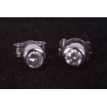 A pair of 18ct white gold rub over set stud earrings set approx. total weight 0.20 carats of round