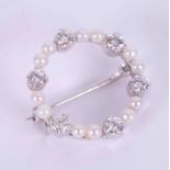 An 18ct white gold circular brooch set with twelve little cultured pearls & six round brilliant