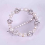 An 18ct white gold circular brooch set with twelve little cultured pearls & six round brilliant