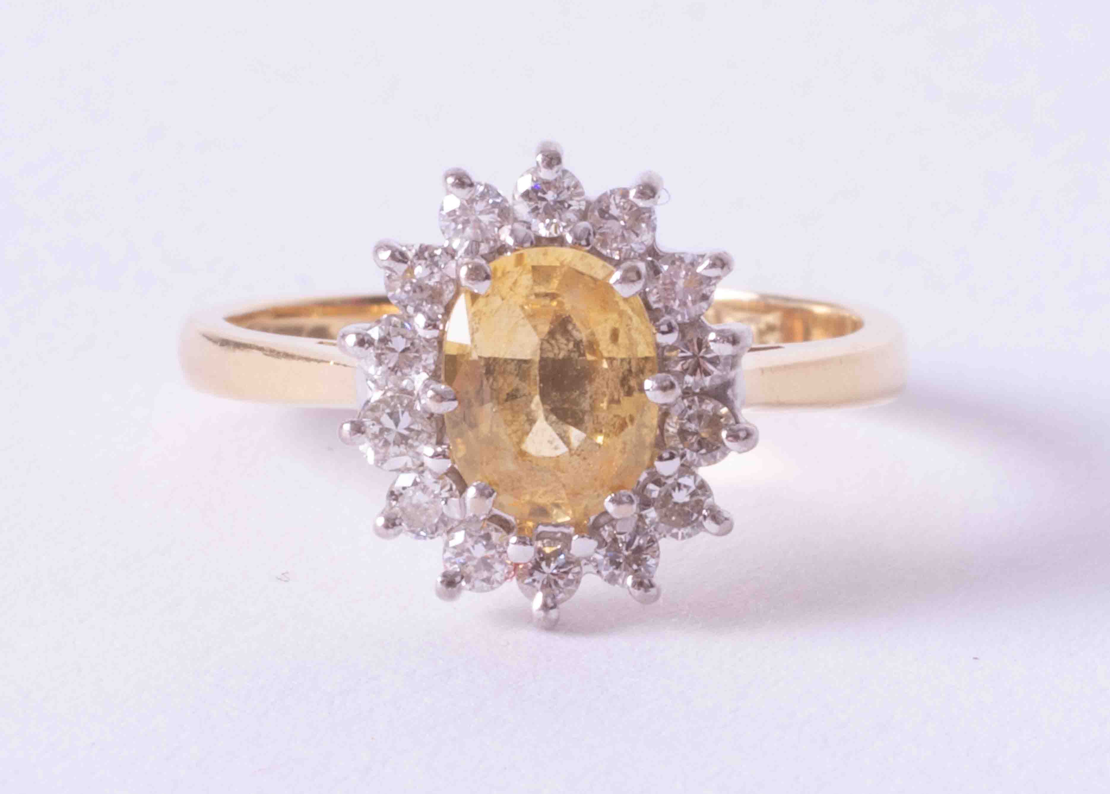 An 18ct yellow & white gold cluster ring set approx. 0.85 carat oval yellow sapphire surrounded by