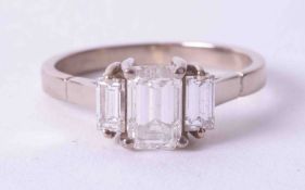 An 18ct white gold three stone ring set with a central emerald cut diamond approx. 0.75 carats