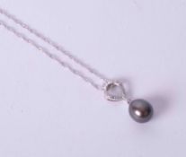 An 18ct white gold pendant set small diamonds & a black oval shaped cultured pearl (length of