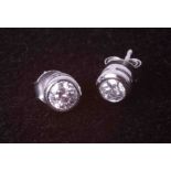 A pair of modern 9ct white gold rub-over round brilliant cut diamond set earrings with post &