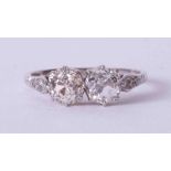 An Art Deco Platinum & 18ct white gold ring set with two central round old cut diamonds each approx.