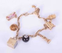 A 14k yellow gold charm bracelet with eight 14k charms to include a snooker ball, Statue of Liberty,