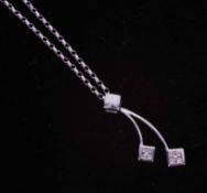 A 9ct white gold drop pendant set eight small diamonds in total with a 9ct white gold 18" fine