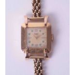 An 18k yellow gold ladies 'Hafis' wristwatch with green stones set to the dial, approx 17.6g.