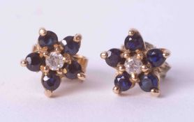 A pair of 9ct yellow gold flower stud earrings set dark blue round sapphires and a small central