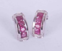 A pair of 9ct white gold earrings set oval cut rubies approx. total weight 0.96 carats with small