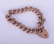 A 9ct rose gold hollow curb link bracelet with heart padlock and safety chain, weight 16.94g.