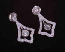 A pair of 18ct white gold Art Deco style drop earrings with a central drop rub over set diamond,