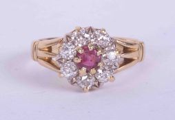 An 18ct yellow gold split shoulder cluster ring set central ruby approx. 0.25 carats, surrounded