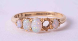 An 18ct yellow gold five stone ring set with cabochon cut white opals (one missing), the opals