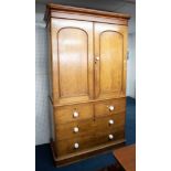 A Victorian stained pine linen press, upper section fitted with sliding trays, the base with two