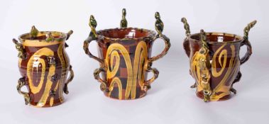 Three Westcountry pottery Tygs, one marked 'WL 98' to base (3). The proceeds from this lot will be