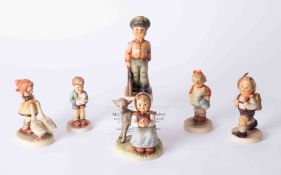 A collection of six Hummel figurines and stand.