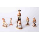 A collection of six Hummel figurines and stand.