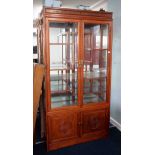 A modern Chinese style rosewood display cabinet, fitted with two glazed doors enclosing an