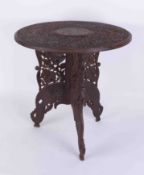 An Anglo Indian carved hardwood table (in two pieces with folding base, label Ganoomals Curios).