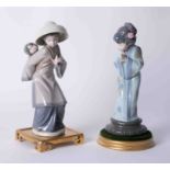 Two Oriental figures on stands, the tallest 27cm, all boxed.