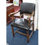 An oak framed elbow chair upholstered in faux leather.