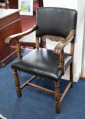 An oak framed elbow chair upholstered in faux leather.