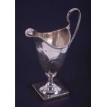 A George III silver helmet shaped cream jug with engraved decoration, monogram within a cartouche,