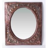 A copper Art Nouveau framed mirror with embossed decoration, 61cm x 51cm.