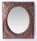 A copper Art Nouveau framed mirror with embossed decoration, 61cm x 51cm.