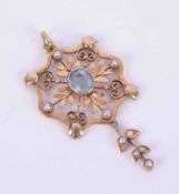 An Edwardian gold (not tested) flower & leaf design pendant set seed pearls & oval cut aquamarine,