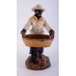 A Continental majolica figure of a black boy carrying a straw basket, height approx 51cm.