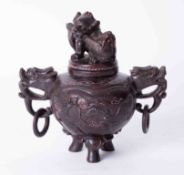 An oriental carved sensor in a red hardstone? with cover, height 21cm.