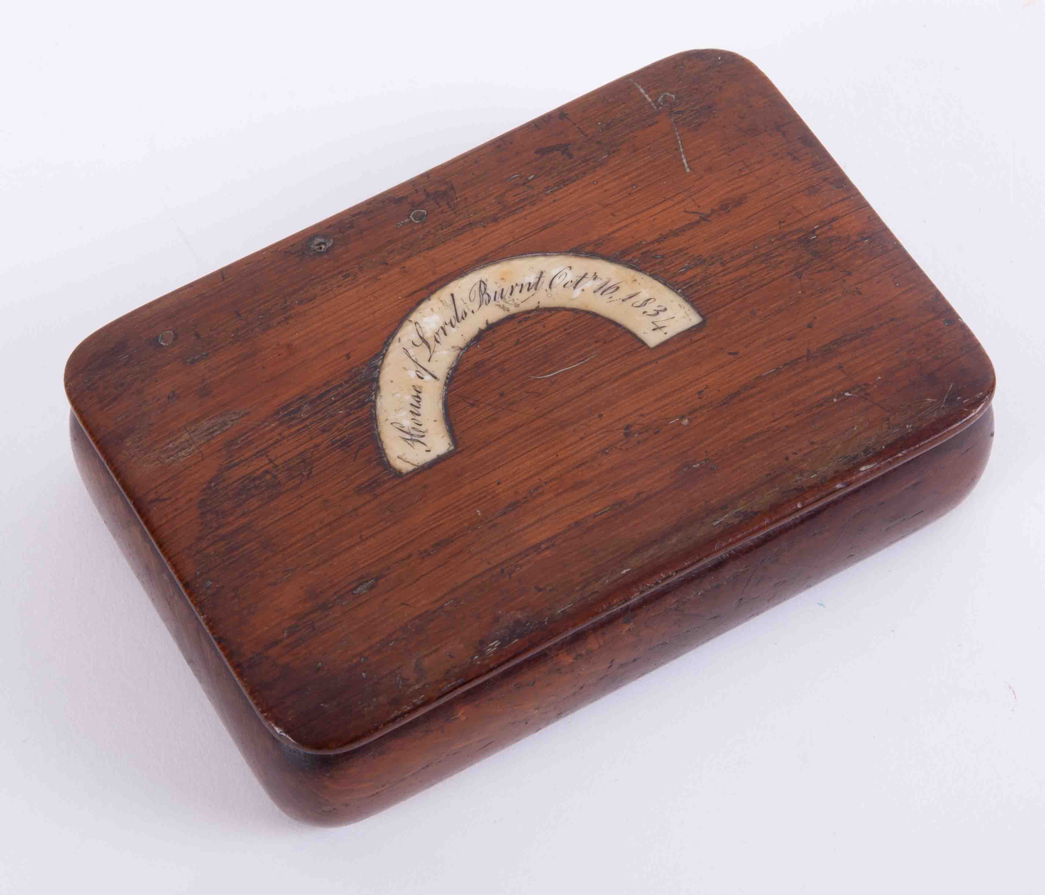 A wood snuff box with inset plaque marked 'House of Lords, burnt October 16th 1834', 11cm x 7cm.