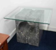 A modern glass top coffee table on a faux stone base, height 54cm, width of glass 69cm.