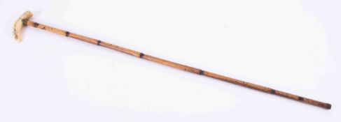 A walking cane with carved Chinese? With a carved landscape knop, length 84cm.