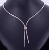 An 18ct white gold choker style articulated necklace with a knot finish, set half way up with