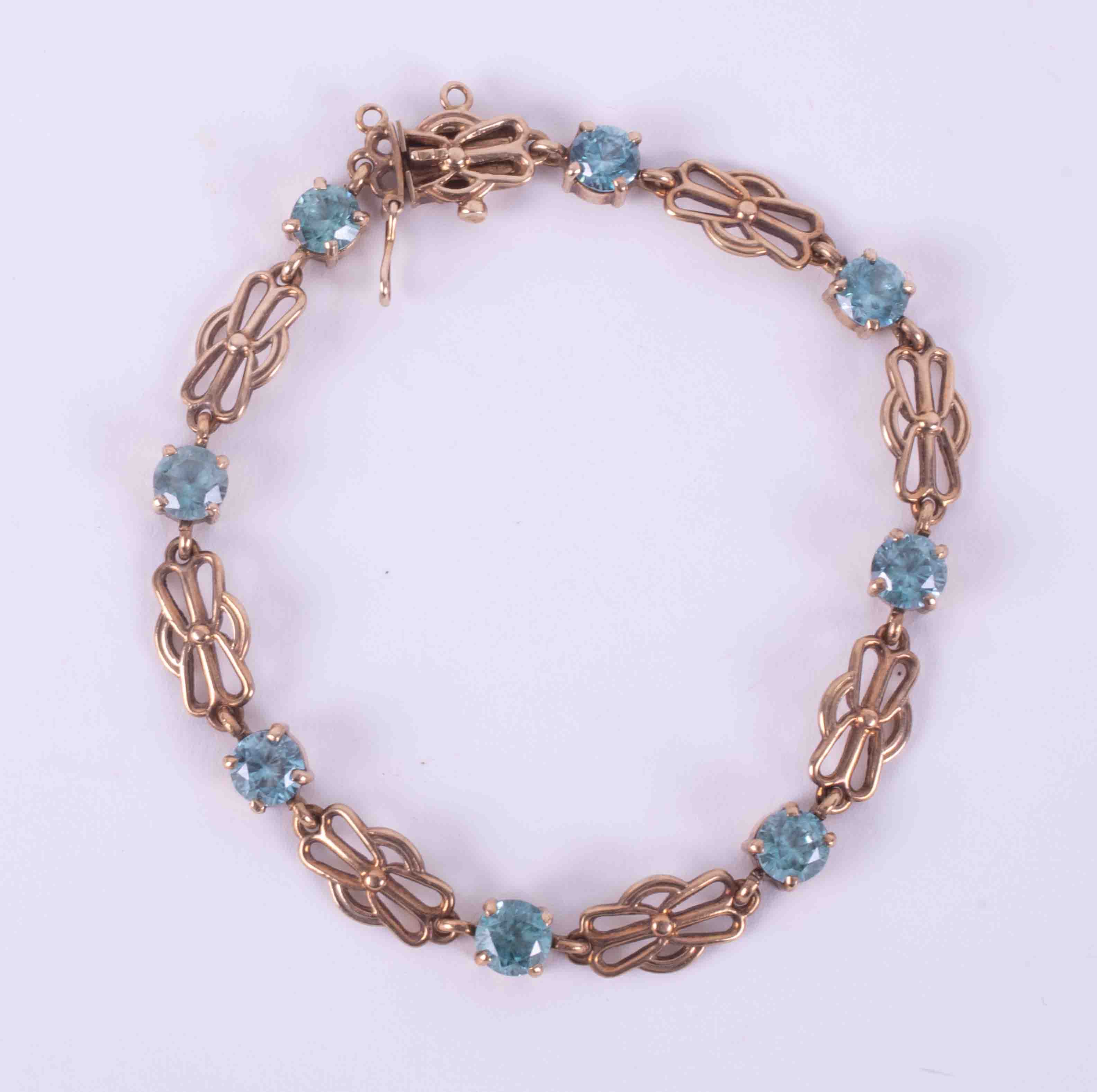 A 9ct yellow gold fancy link bracelet set with eight blue round faceted stones (possibly blue zircon