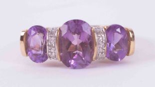 A 9ct yellow gold ring set with three oval cut amethysts, approx. 3.15 carats with small interspaced