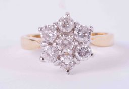 An 18ct yellow & white gold flower cluster ring set with approx. 1.20 carats total weight of round