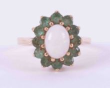 A 9ct yellow gold cluster ring set with a cabochon cut oval white opal, approx. 8.4mm x 6.4mm,